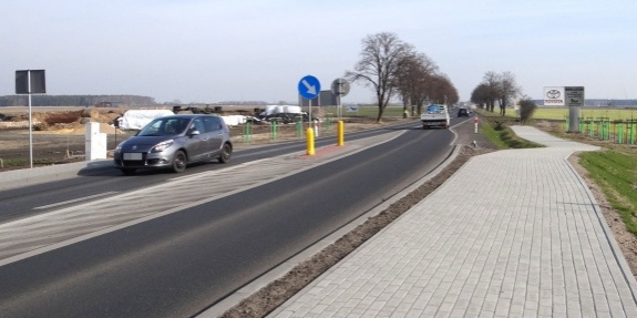 Odcinek drogi w Lasocicach na której ma powstać ścieżka rowerowa. Na zdjęciu widoczne samochody&nbsp;