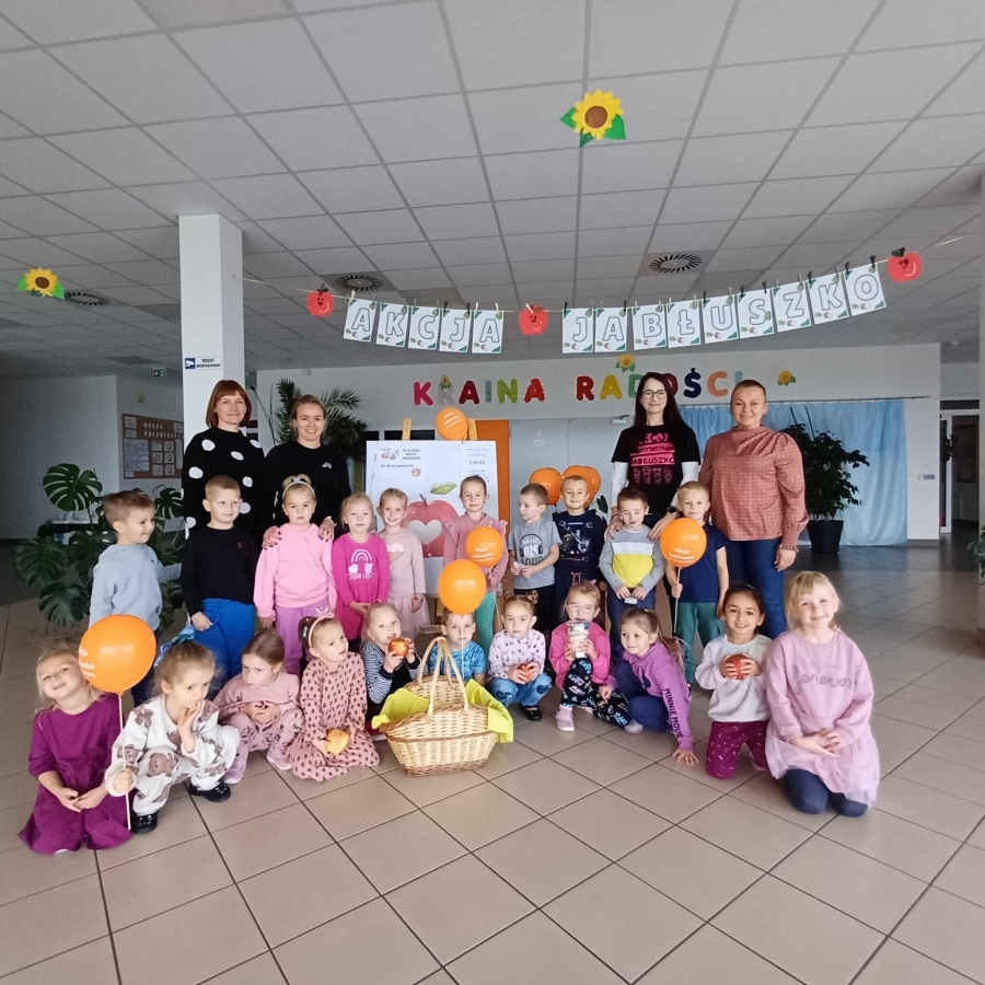 Zdjęcie grupowe dzieci z jabłkami w holu przedszkola&nbsp;