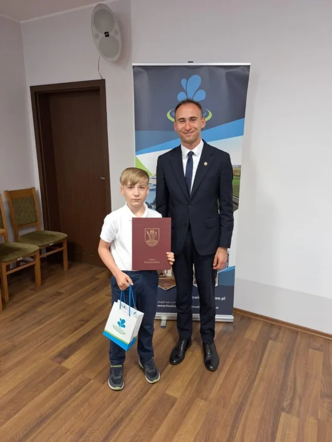 Na zdjęciu Wójt Gminy wraz z Oliwierem Kucfir ( w ręku trzyma dyplom oraz upominek )