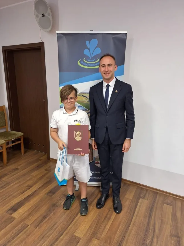 Na zdjęciu Wójt Gminy wraz z Borysem Gorwą ( w ręku trzyma upominek oraz dyplom )