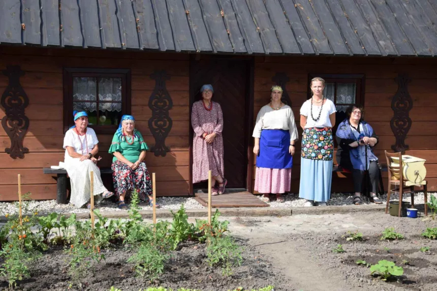 Na zdjęciu Izba Tradycji. Przed izbą stoją kobiety zapraszając do środka