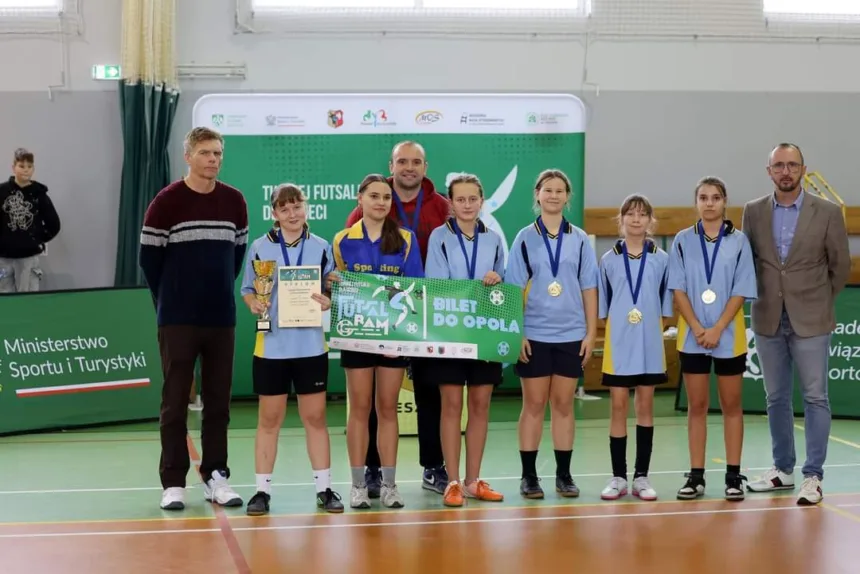 Zdjęcie drużyny ze Święciechowy wraz z trenerem i organizatorami z medalami i biletem do Opola