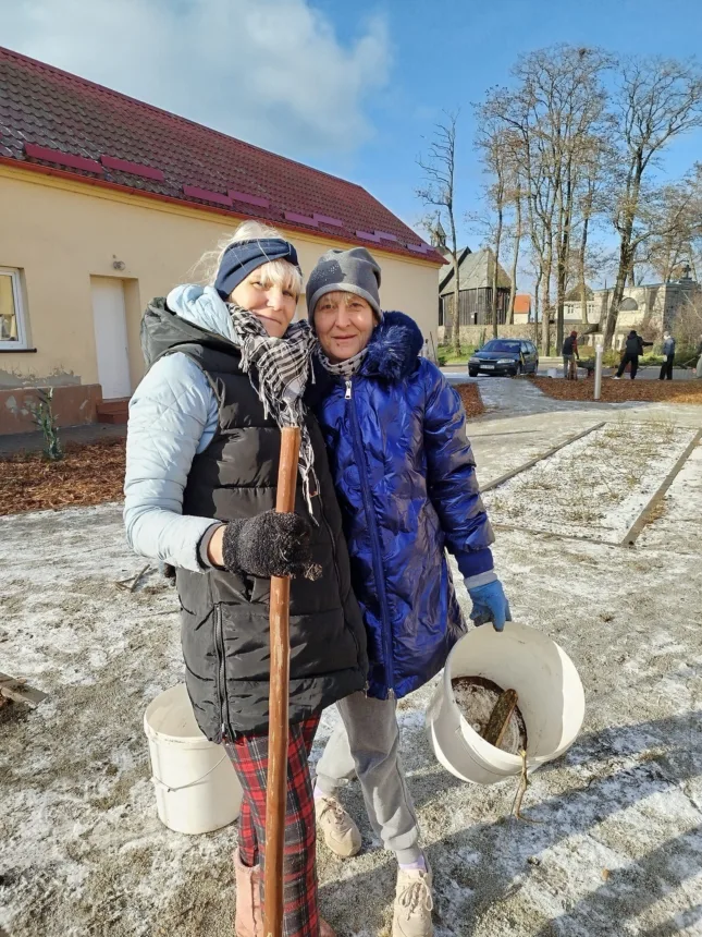 Zdjęcie dwóch kobiet z wiadrami pozującymi do zdjęcia