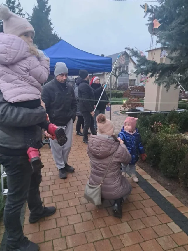 Ujęcie podczas ubierania choinki przed dorosłych i dzieci