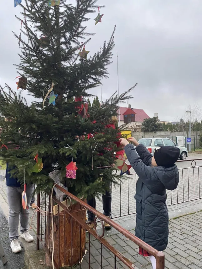 Ujęcie gdzie dziewczynka zawiesza bombkę na choince