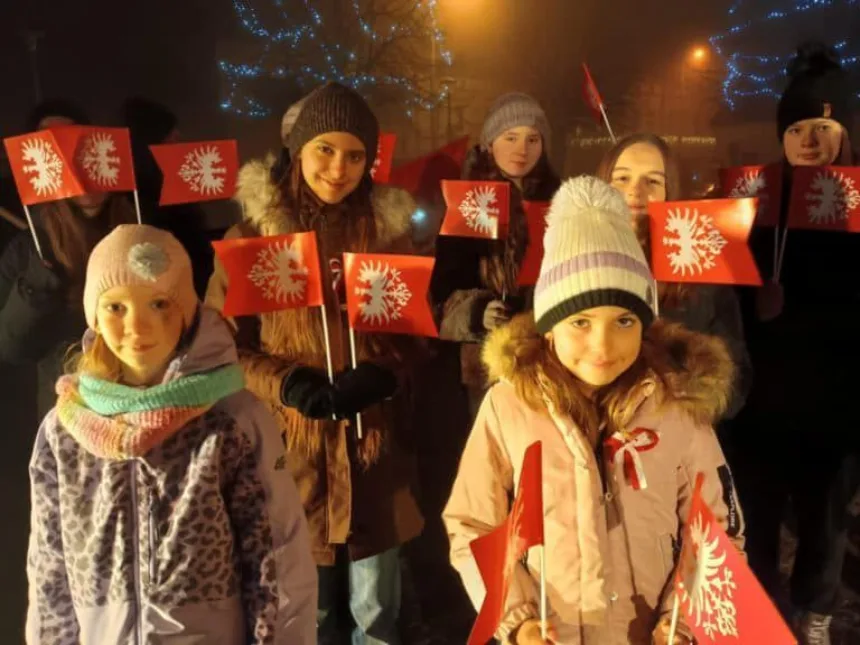 Na zdjęciu dzieci z flagami wielkopolskimi przy poniku