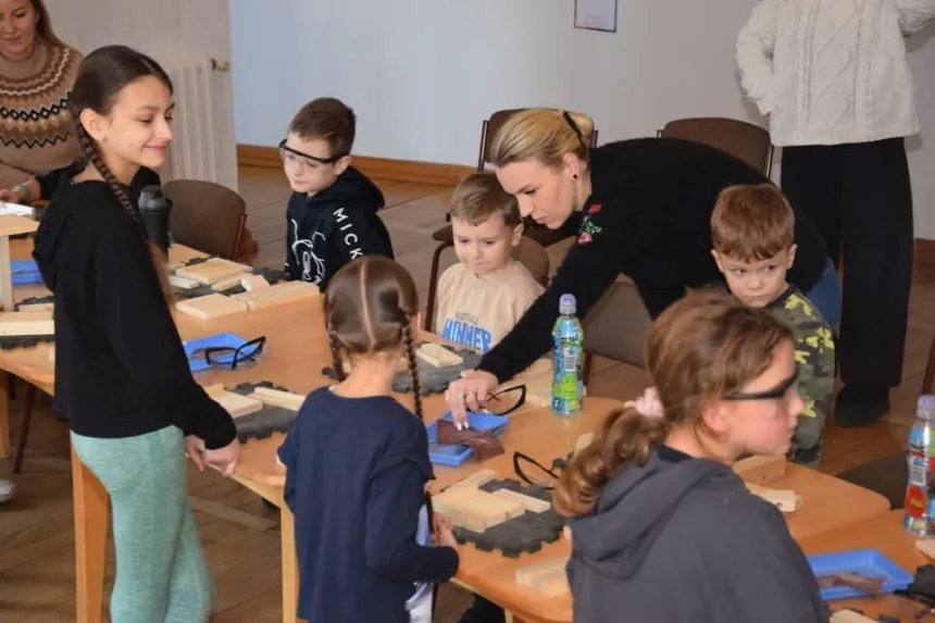 Zdjęcie dzieci wraz z rodzicami podczas wykonywania lampionu